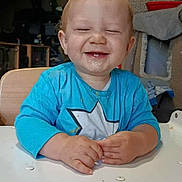 Emrys participe au concours pour gagner de l'argent avec cette photo : toddler, child, smiling, happy, messy, blue_shirt, star, indoor, table, hands, face, hair, teeth, furniture, background, cozy, seat, expression, person, young_child