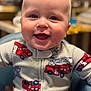 baby, child, smiling, face, onesie, fire_truck, high_chair, indoor, cute, happy, infant, young_child, clothing, portrait, sitting, closeup, head, expression, person, fun