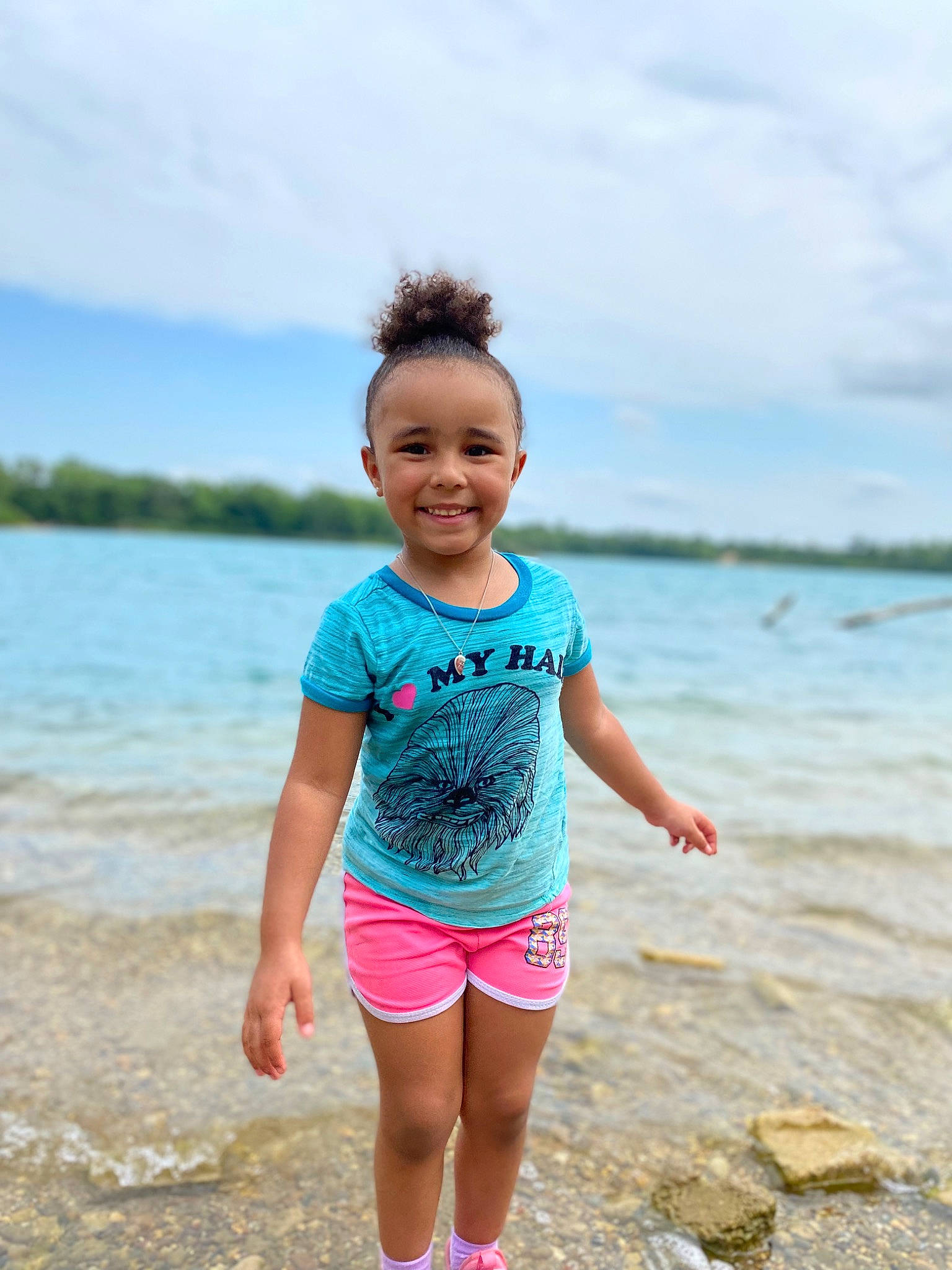 Adalynn is registered to the contest to win money with this photo: beach, cloud, electric_blue, face, happy, joy, lake, leisure, people_in_nature, person, recreation, sand, shorts, sky, sleeve, smile, summer, t_shirt, thigh, toddler