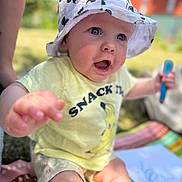 Tobias participe au concours pour gagner de l'argent avec cette photo : baby, child, hat, mickey_mouse, bucket_hat, yellow_shirt, snack, crayon, drawing, outdoor, grass, blanket, summer, cute, smiling, happy, person, portrait, sitting, playful