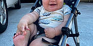 Maven joined the competition — help win amazing prizes! baby, child, stroller, smiling, foot, dinosaur_pattern, outdoor, driveway, car, wheel, clothing, happy, person, seatbelt, summer, playful, infant, cute, sunlight, metal_frame