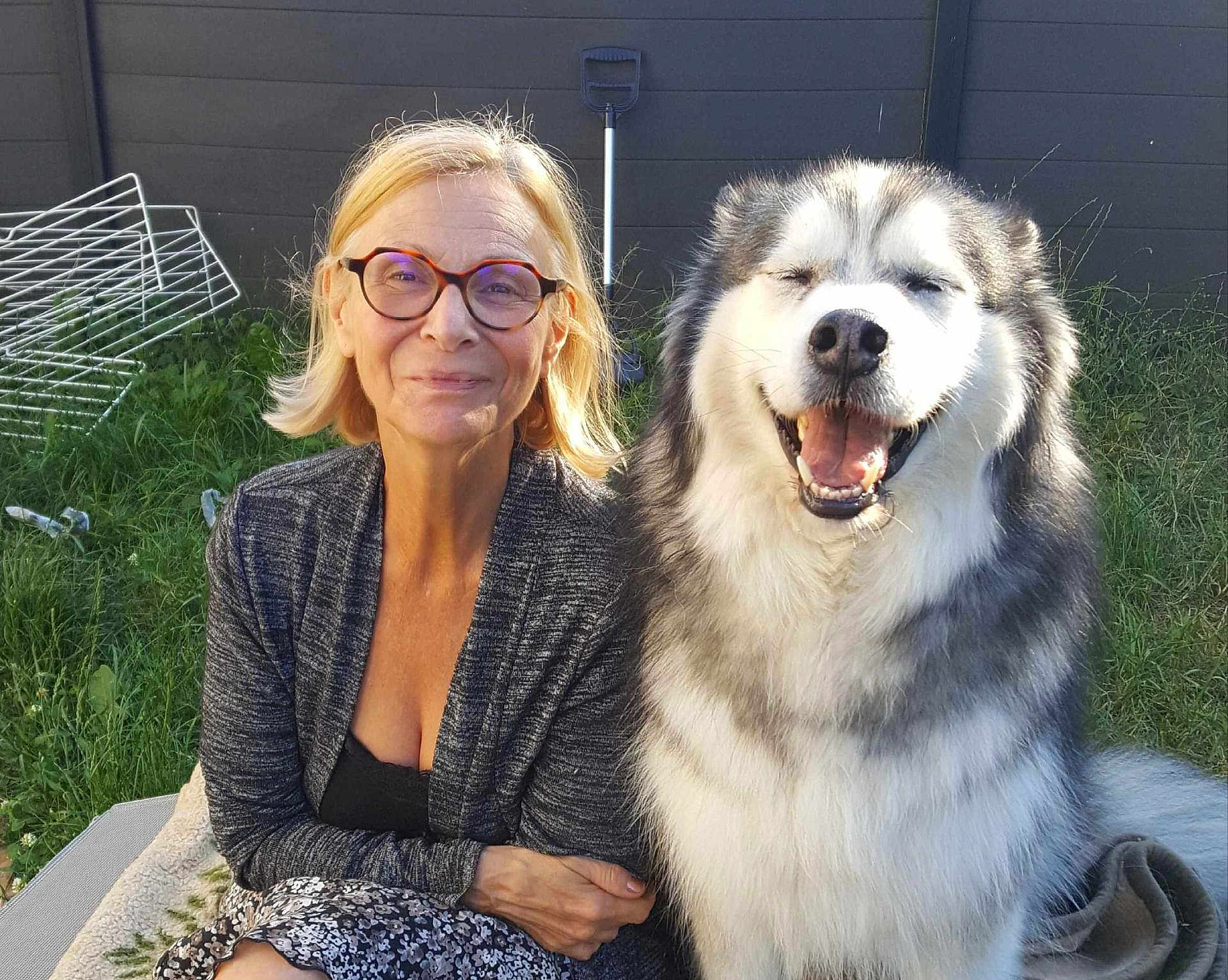Jencko a rejoint le concours — aidez-le/la à gagner de superbes lots ! woman, dog, smiling, glasses, outdoor, grass, fence, happy, fluffy_dog, pet, nature, casual_clothing, sitting, portrait, daylight, person, animal, friendship, companionship, relaxation