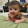baby, infant, child, face, smile, eyes, hair, blanket, bed, dressing_table, mirror, room, furniture, home, curious, clothing, skin, hand, lying, indoors