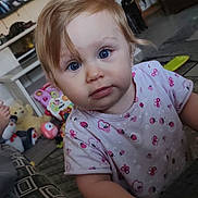 Ambre participe au concours pour gagner de l'argent avec cette photo : blonde_hair, blue_eyes, butterfly_pattern, carpet, child, close_up, couch, curious_expression, foot, furniture, indoor, ladybug_pattern, living_room, person, pink_shirt, playful, stuffed_animals, toddler, toys, young