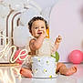 baby, birthday, cake, celebration, child, smiling, balloon, party, dress, floor, happy, face, hands, decorations, one, neon_sign, foot, cute, indoor, photography