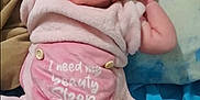 Maylee is registered to the contest to win money with this photo: arms, baby, bed, child, cozy, cute, diaper, expression, fabric, face, happy, indoor, infant, laying_down, newborn, person, pillow, pink_clothing, smiling, socks