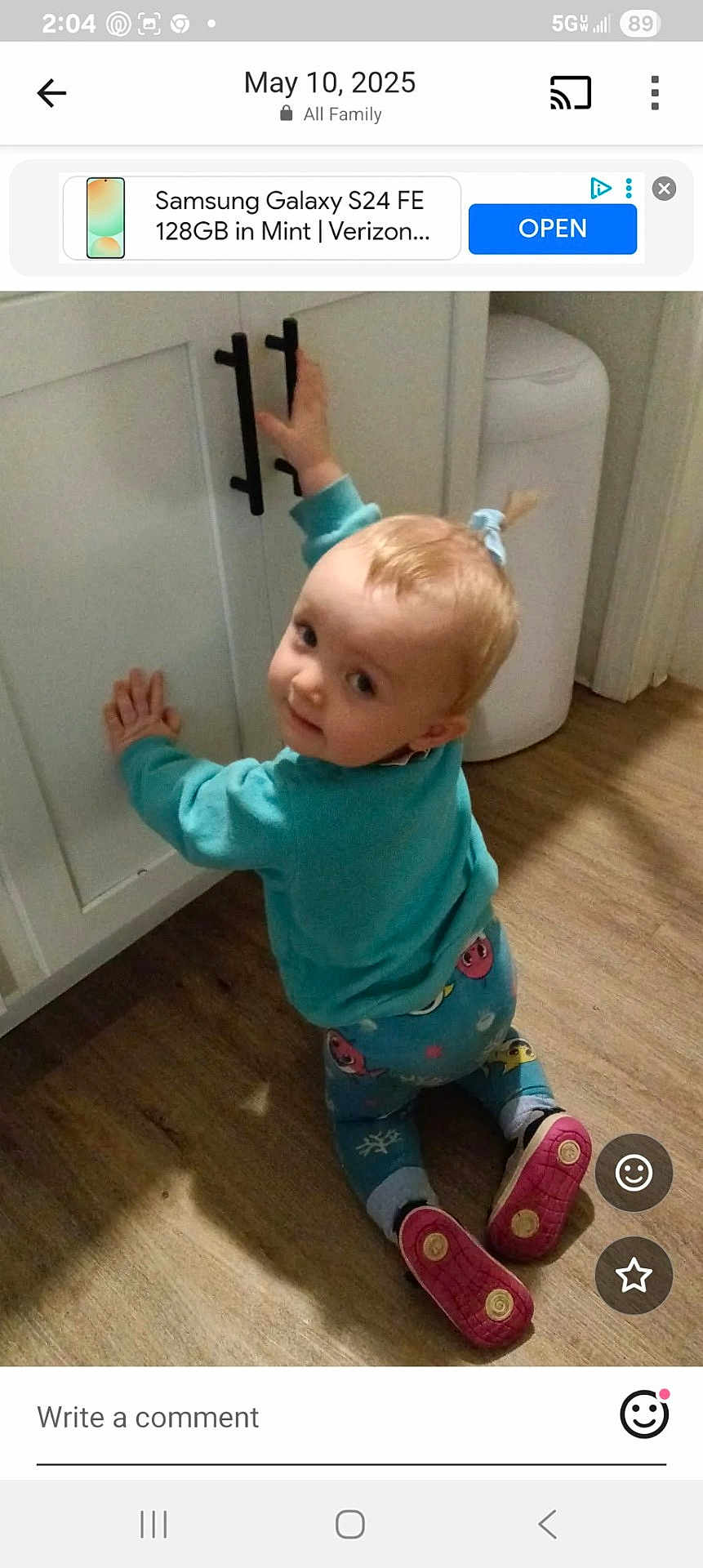 Maylee is registered to the contest to win money with this photo: toddler, child, pajamas, cabinet, kitchen, wood_floor, curious, indoor, baby, footwear, toy_pattern, sweater, blond_hair, playful, crawling, young_child, home_interior, person, looking_back, floor