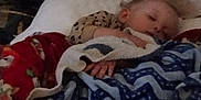 Maylee is registered to the contest to win money with this photo: child, sleeping, blanket, plush_toy, pillow, bed, cozy, indoors, resting, comfort, soft, warm, cute, peaceful, nap, furniture, person, clothing, head, hand