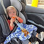black, blanket, blue, brick_wall, car_interior, car_seat, casual, child, clothing, drink_container, gray, indoor, orange, person, seatbelt, shoes, toddler, vehicle, window, yellow