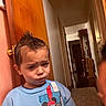 Elijah joined the competition — help win amazing prizes! child, toddler, mohawk, blue_sweatshirt, mickey_mouse, indoor, hallway, door, wooden_door, carpet, patterned_rug, person, expression, funny_face, curly_hair, light, shadow, home_interior, wall, clothing