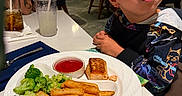 Elijah joined the competition — help win amazing prizes! child, boy, food, broccoli, potato_wedges, fish, ketchup, plate, restaurant, table, drink, glass, napkin, fork, person, dining, indoor, clothing, face, expression