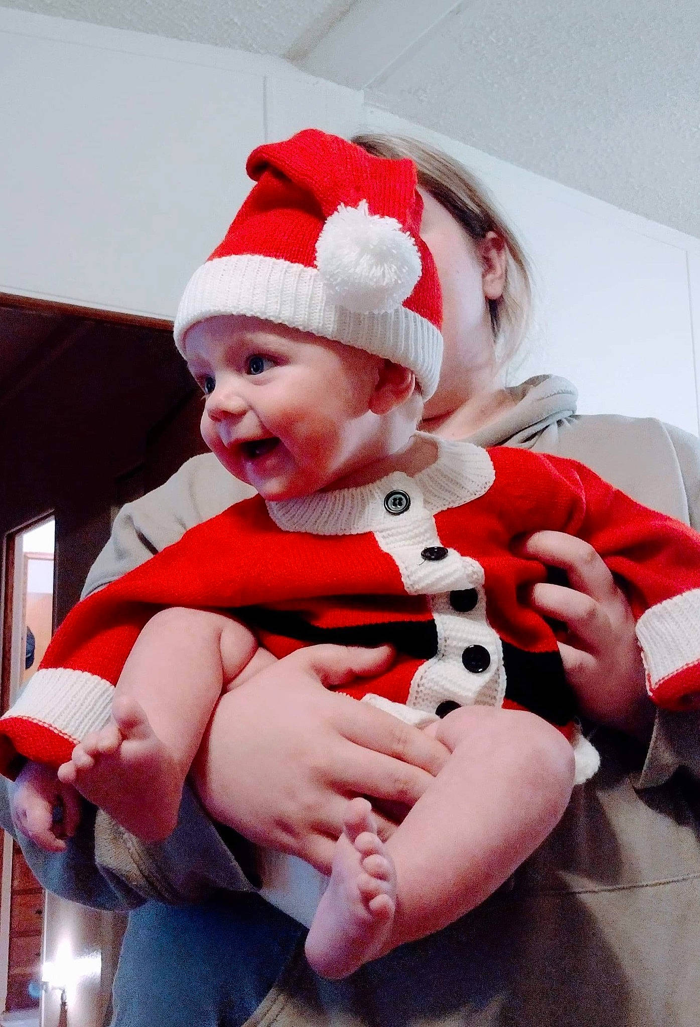 Nathaniel is registered to the contest to win money with this photo: baby, baby_toddler_clothing, carmine, costume_hat, event, fictional_character, finger, fun, fur, gesture, glove, happy, hat, headgear, headwear, lap, person, pink, santa_claus, sleeve