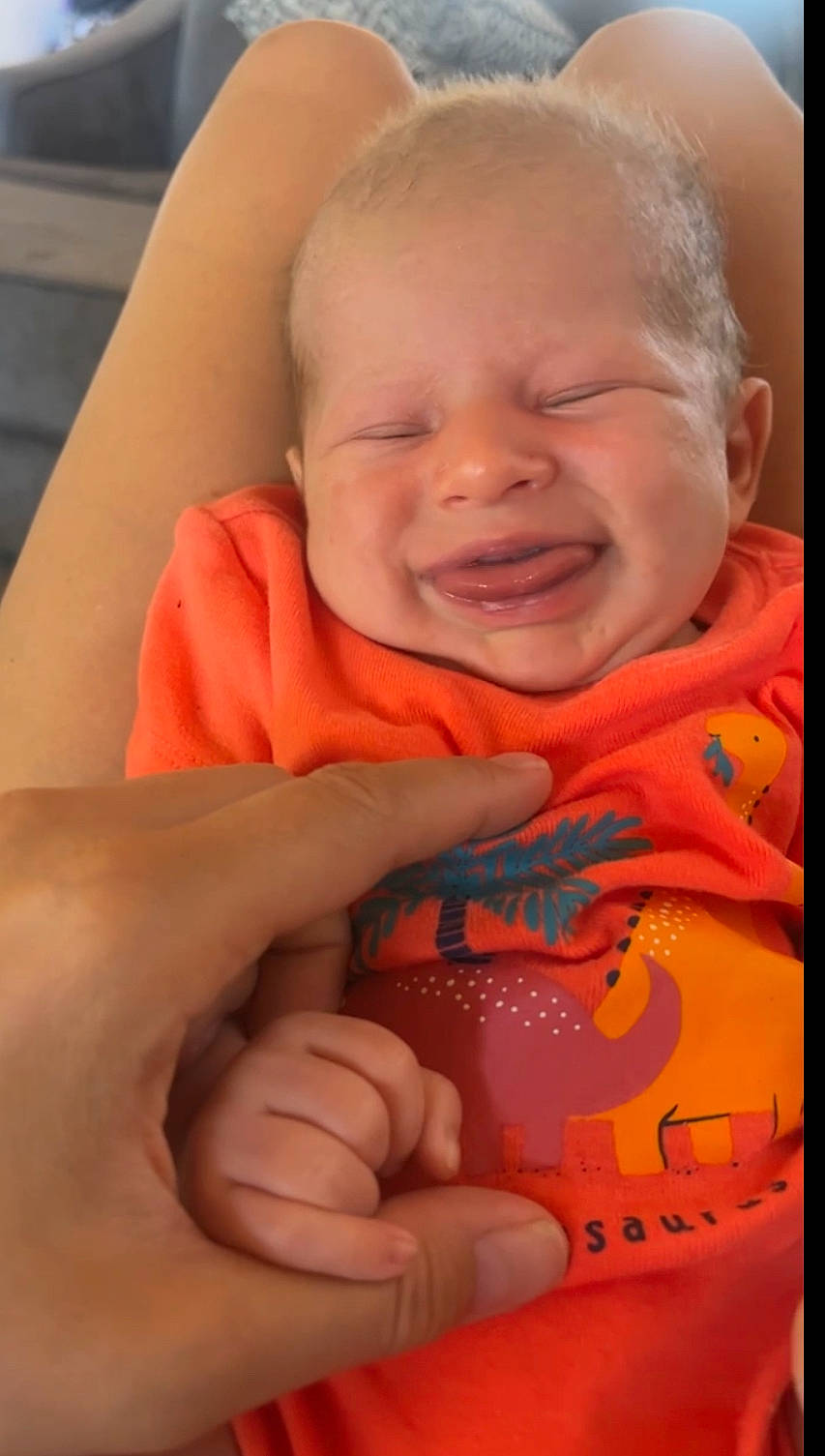 Kayne is registered to the contest to win money with this photo: baby, cheek, chest, eye, eyebrow, finger, gesture, hand, happy, human_body, iris, lip, mouth, nose, orange, person, skin, smile, thumb, toddler