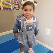 Aylani Michelle joined the competition — help win amazing prizes! toddler, child, denim_jacket, bow, play_mat, classroom, poster, education, days_of_week, shapes, smiling, standing, shoes, socks, wall, outfit, happy, indoor, person, cute