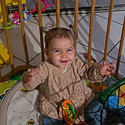 Lou participe au concours pour gagner de l'argent avec cette photo : toddler, child, smiling, playpen, toy, indoor, pigtails, happy, baby, clothing, sitting, floor, playmat, colorful, cute, person, young_child, furniture, home, portrait