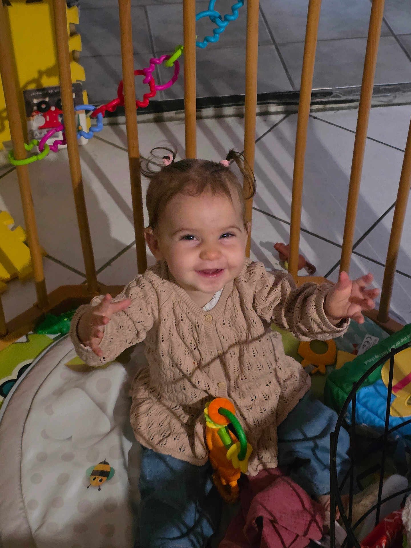 Lou participe au concours pour gagner de l'argent avec cette photo : toddler, child, smiling, playpen, toy, indoor, pigtails, happy, baby, clothing, sitting, floor, playmat, colorful, cute, person, young_child, furniture, home, portrait