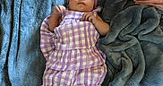 Brookelyn is registered to the contest to win money with this photo: baby, baby_accessories, blanket, child, clothing, comfort, cozy, cute, fabric, floral_pattern, headband, indoor, infant, lying_down, person, pink_flower, portrait, purple_outfit, shoes, soft_texture