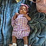Brookelyn is registered to the contest to win money with this photo: baby, infant, child, purple_outfit, headband, blanket, soft_texture, shoes, floral_pattern, pink_flower, lying_down, indoor, cozy, cute, clothing, person, portrait, baby_accessories, fabric, comfort