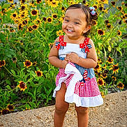 Malahney joined the competition — help win amazing prizes! barefoot, blue, bows, child, cute, dress, flowers, garden, greenery, happy, nature, outdoor, portrait, red, smiling, standing, sunlight, toddler, white, yellow_flowers