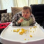 Lylah Ruth is registered to the contest to win money with this photo: baby, high_chair, scrambled_eggs, bib, pout, indoor, pillows, curtains, food, child, meal_time, smile, face, clothing, furniture, cute, messy, home, person, table