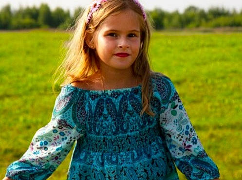 Camille participe au concours pour gagner de l'argent avec cette photo : baby_toddler_clothing, dress, face, facial_expression, grass, grassland, hairstyle, happy, head, meadow, neck, outerwear, people_in_nature, person, plant, shoulder, sleeve, standing, sunlight, toddler