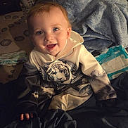 Mason joined the competition — help win amazing prizes! toddler, child, smiling, hoodie, tiger_print, blanket, indoor, cozy, happy, face, clothing, person, baby, seated, soft_texture, warm_lighting, blue_eyes, casual_wear, portrait, cute