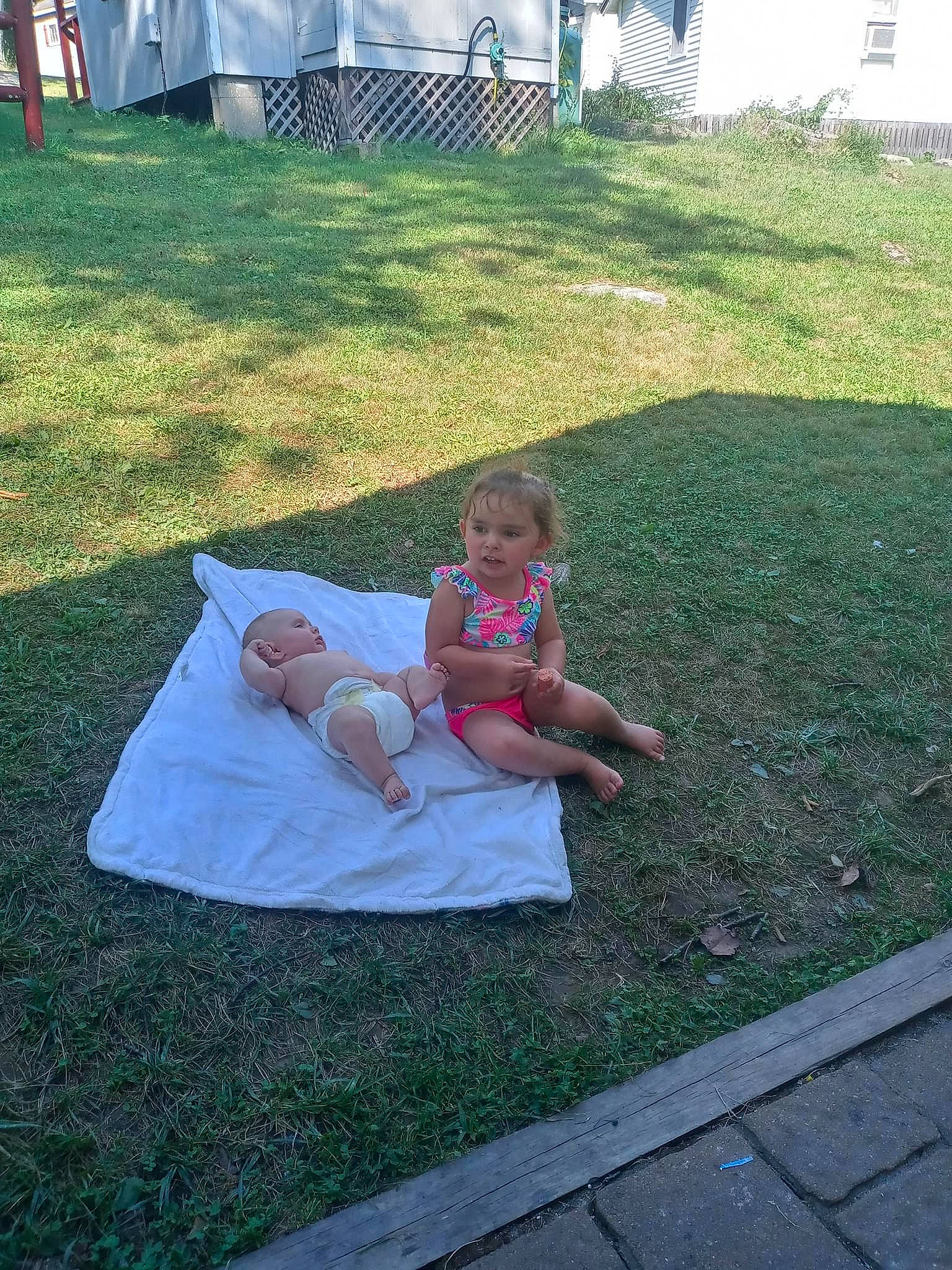 Maddison is registered to the contest to win money with this photo: baby, child, event, fun, garden, grass, grass_family, lawn, leisure, outdoor_furniture, person, recreation, road_surface, shade, shorts, sidewalk, sitting, t_shirt, table, tent