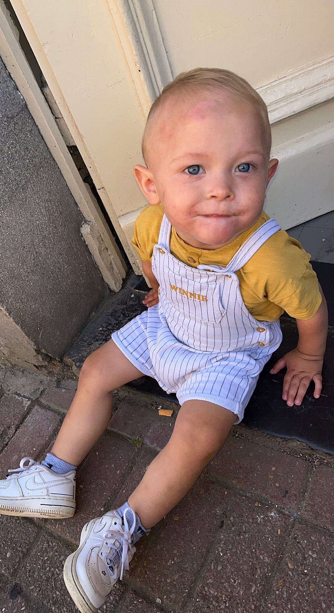 Timaël participe au concours pour gagner de l'argent avec cette photo : baby, baby_toddler_clothing, dress, finger, floor, flooring, footwear, fun, joint, joy, knee, leg, mammal, person, road_surface, shoe, shorts, smile, sneakers, thigh
