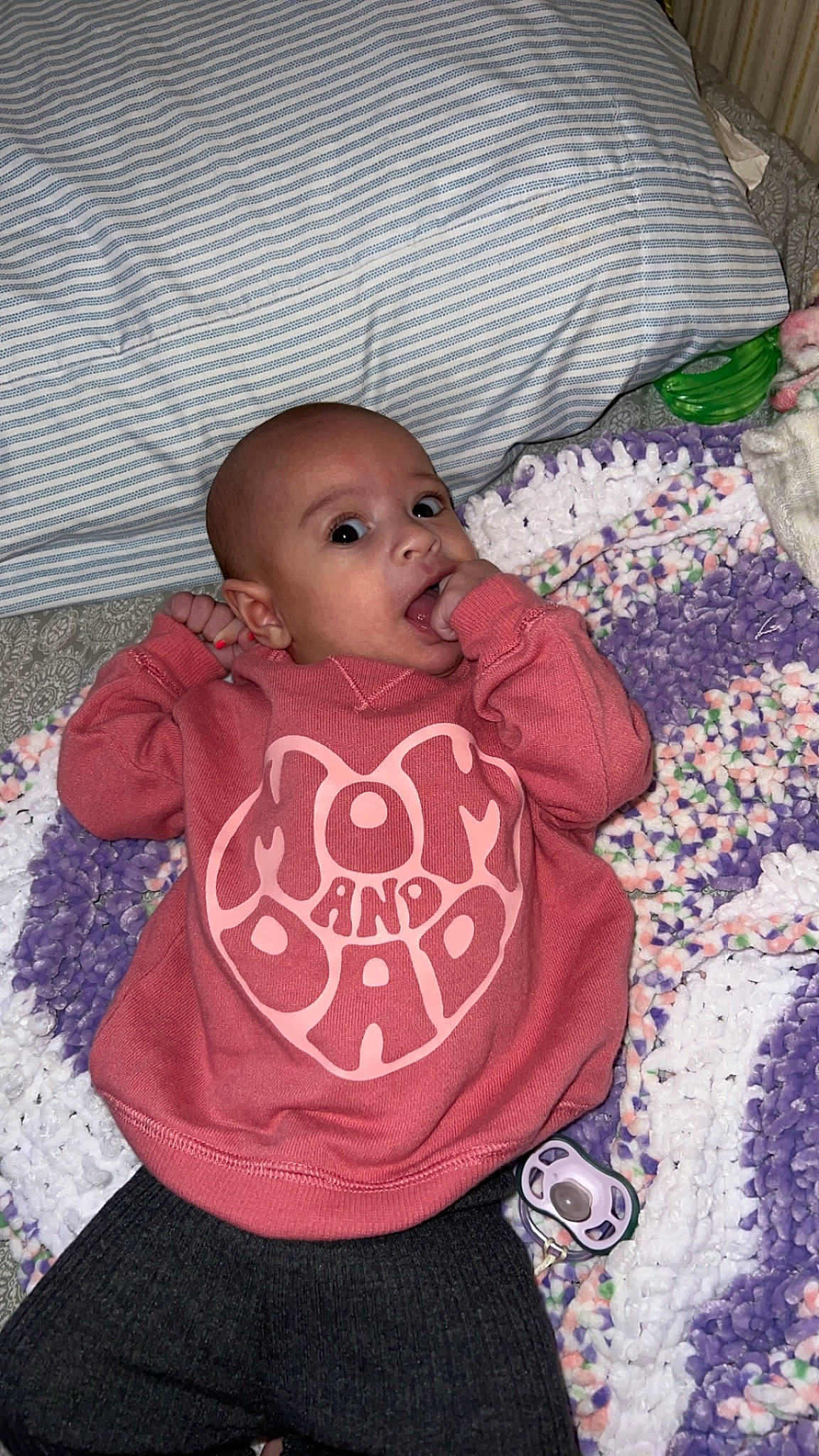 Leilani is registered to the contest to win money with this photo: baby, baby_products, baby_toddler_clothing, bib, carmine, cheek, child, eye, happy, head, headgear, hood, linens, pattern, person, pink, room, sitting, sleeve, t_shirt