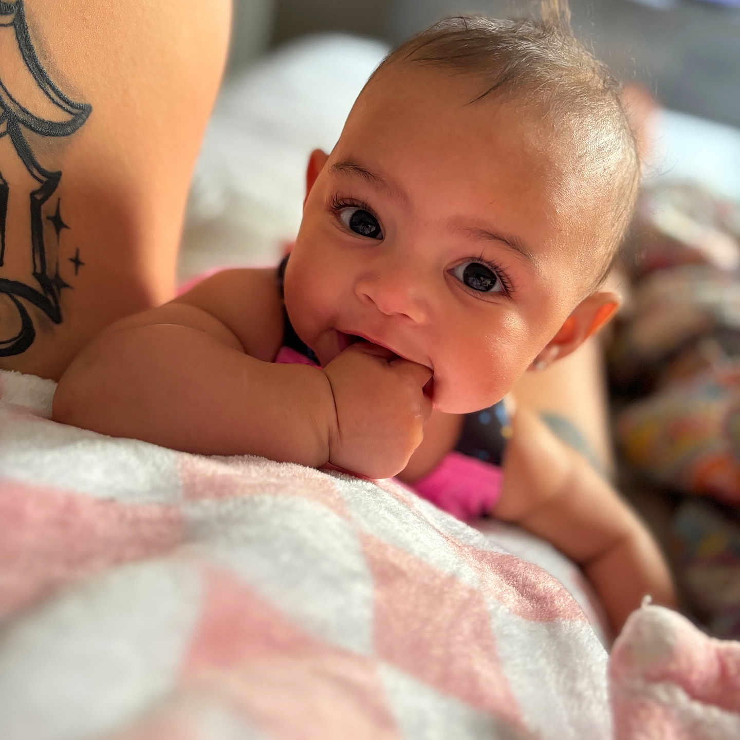 Lyric joined the competition — help win amazing prizes! baby, blanket, chewing, child, closeup, cute, expression, eyes, face, fist, hand, indoors, infant, lying, person, pink, skin, soft, tattoo, white