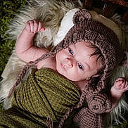 Kilynn joined the competition — help win amazing prizes! baby, infant, knitted_hat, bear_hat, crocheted_toy, teddy_bear, blanket, green_blanket, fluffy_rug, white_rug, curious, lying_down, indoor, portrait, cute, child, soft_lighting, close_up, hand, face