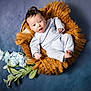 Kilynn is registered to the contest to win money with this photo: baby, infant, basket, blue_background, flowers, soft_clothing, cozy, woven_texture, cute, portrait, newborn, child, laying_down, smiling, indoor, head, small_hands, small_feet, curious, relaxed