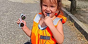 Camélia participe au concours pour gagner de l'argent avec cette photo : child, daylight, footwear, gravel_path, lake, life_jacket, nature, outdoor, person, playful, recreation, sandals, smiling, summer, sunglasses, sunny, trees, vacation, water, whistle
