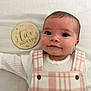 Harriet joined the competition — help win amazing prizes! baby, infant, two_months, plaque, milestone, white_blanket, pink_overalls, checkered_pattern, smile, face, cute, portrait, lying_down, wooden_sign, button, clothing, child, newborn, person, indoors