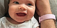 Harriet joined the competition — help win amazing prizes! baby, smile, happy, infant, hand, arm, watch, pink_watch_band, couch, clothing, onesie, face, skin, person, fingers, closeup, indoor, joy, expression, comfort