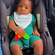 Edric joined the competition — help win amazing prizes! baby, child, car_seat, toy, bib, green_clothing, white_shoes, striped_socks, indoor, car_interior, serious_expression, infant, seatbelt, child_safety, person, cute, small_hands, black_hair, plush_seat, casual_wear