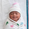 Xiomara is registered to the contest to win money with this photo: newborn, baby, infant, smiling, wrapped, blanket, hat, pom_pom, hospital, bed, white, colorful, handprints, sleeping, cozy, cute, child, portrait, resting, cute_baby