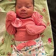 Xiomara joined the competition — help win amazing prizes! baby, infant, pacifier, pink_clothing, colorful_pants, blanket, ladybug_pattern, butterfly_pattern, cute, lying_down, soft_lighting, indoor, young_child, newborn, fabric, comfort, resting, portrait, child, cozy