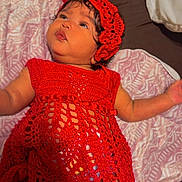 Nailani joined the competition — help win amazing prizes! arm, baby, baby_clothing, blanket, child, crochet, curious, cute, face, hat, headwear, indoors, infant, lying_down, patterned_blanket, portrait, red_dress, skin, soft_texture, young_child