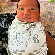 Aemond is registered to the contest to win money with this photo: baby, infant, swaddled, blanket, pattern, face, eyes, expression, indoor, carpet, floor, person, hand, skin, head, newborn, cute, child, portrait, clothing