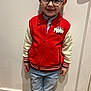child, boy, glasses, red_jacket, marvel, jeans, socks, standing, smiling, indoor, wooden_floor, door, casual_clothing, portrait, happy, young, fashion, person, cute, home