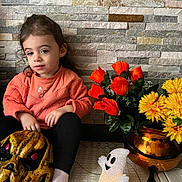 Laïa a rejoint le concours — aidez-le/la à gagner de superbes lots ! toddler, child, orange_sweater, black_pants, white_sock, halloween_mask, ghost_decoration, orange_flowers, yellow_flowers, flower_vase, copper_vase, stone_wall, indoor, sitting, toy, decoration, holiday, face, person, floor