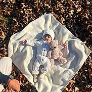Waris joined the competition — help win amazing prizes! baby, blanket, autumn_leaves, teddy_bear, knit_hat, knit_outfit, baby_clothing, person, hand, watch, outdoor, fall, nature, child, cute, soft_toy, lying_down, warm_clothing, family, tender_moment