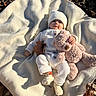 baby, blanket, teddy_bear, autumn_leaves, outdoor, knitwear, hat, child, cute, soft_toy, sunlight, fall, comfort, cozy, infant, portrait, nature, relaxing, warm, smiling