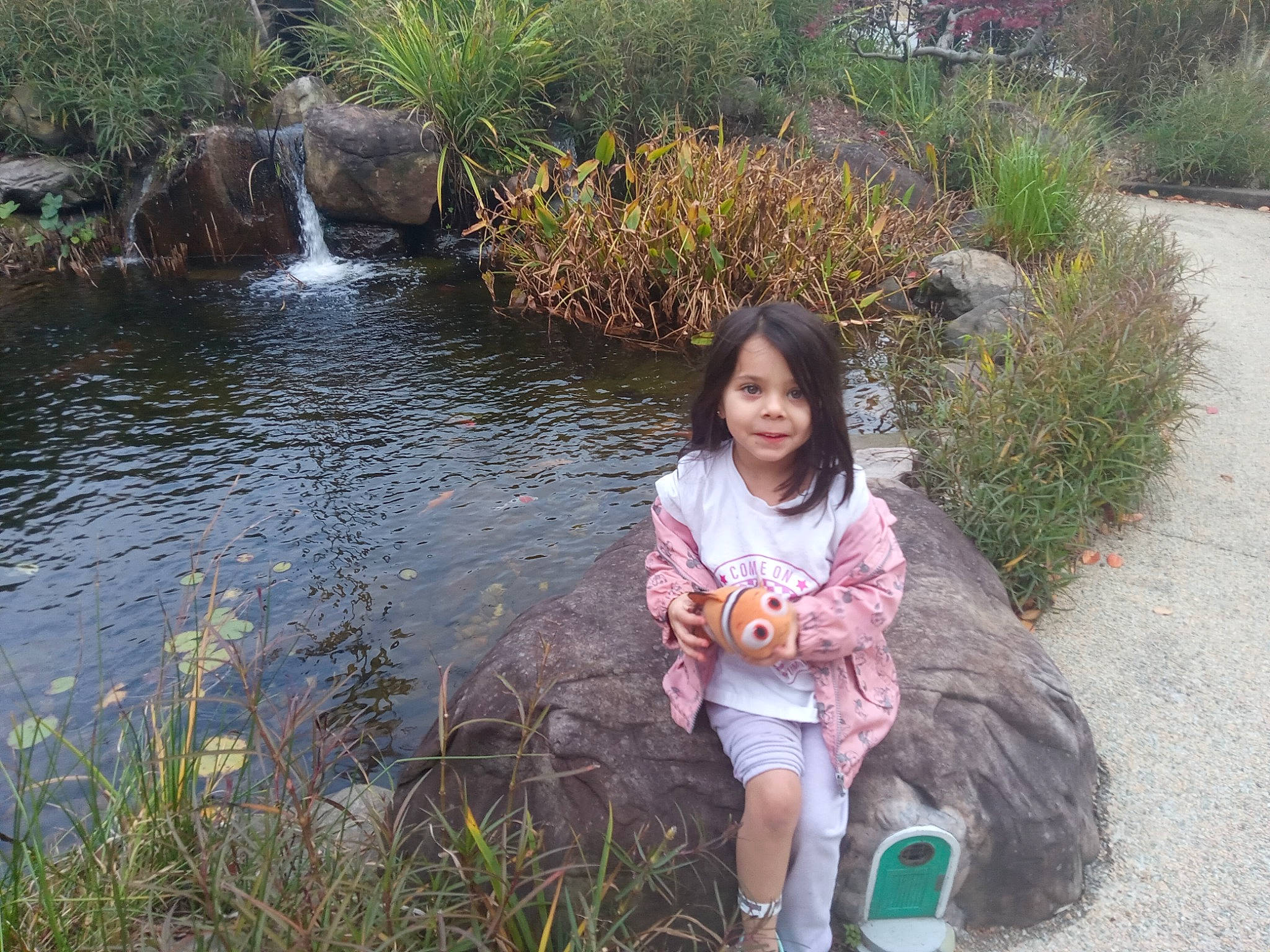 Emilie is registered to the contest to win money with this photo: bank, botany, grass, grass_family, happy, joy, lake, landscape, leaf, leisure, morning, natural_landscape, people_in_nature, person, plant, shrub, spring, toddler, tree, vertebrate