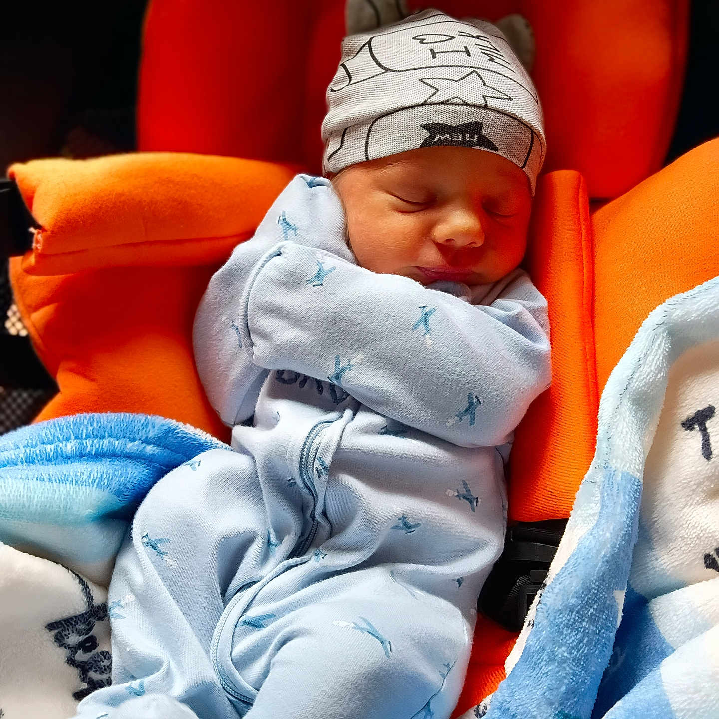 Severus is registered to the contest to win money with this photo: newborn, baby, sleeping, onesie, hat, blanket, orange_seat, cozy, infant, child, cute, resting, peaceful, soft, warm, indoor, portrait, comfort, baby_clothes, sleep