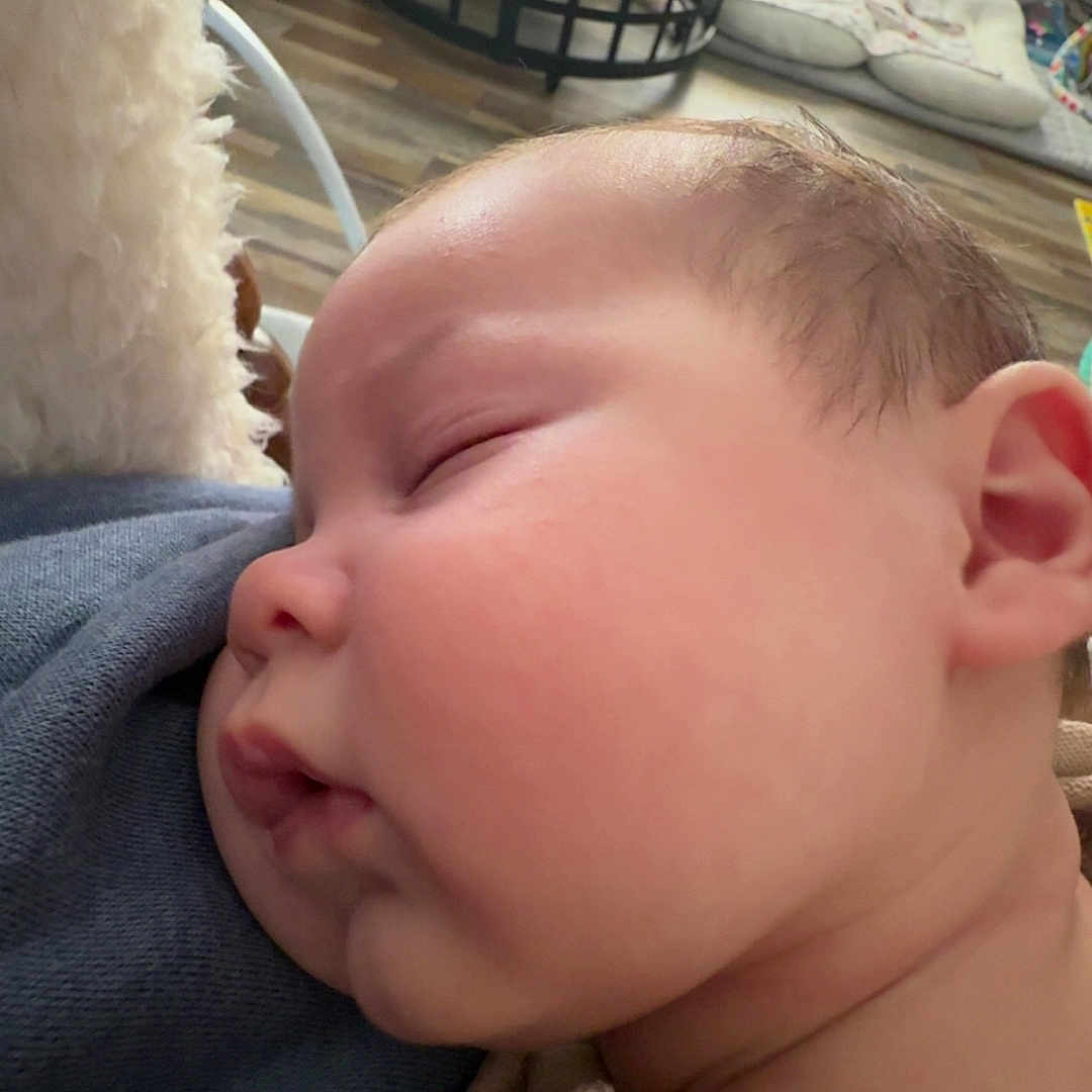 Pierson is registered to the contest to win money with this photo: baby, blanket, cheek, close_up, couch, ear, face, family, head, indoor, infant, living_room, mouth, nap, newborn, peaceful, portrait, sleeping, soft_texture, toys