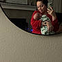 Ella joined the competition — help win amazing prizes! baby, infant, woman, adult, mirror, selfie, smartphone, phone, holding, blanket, tattoo, red_clothing, mantel, home_decor, reflection, portrait, indoor, cozy, smile, wall_texture