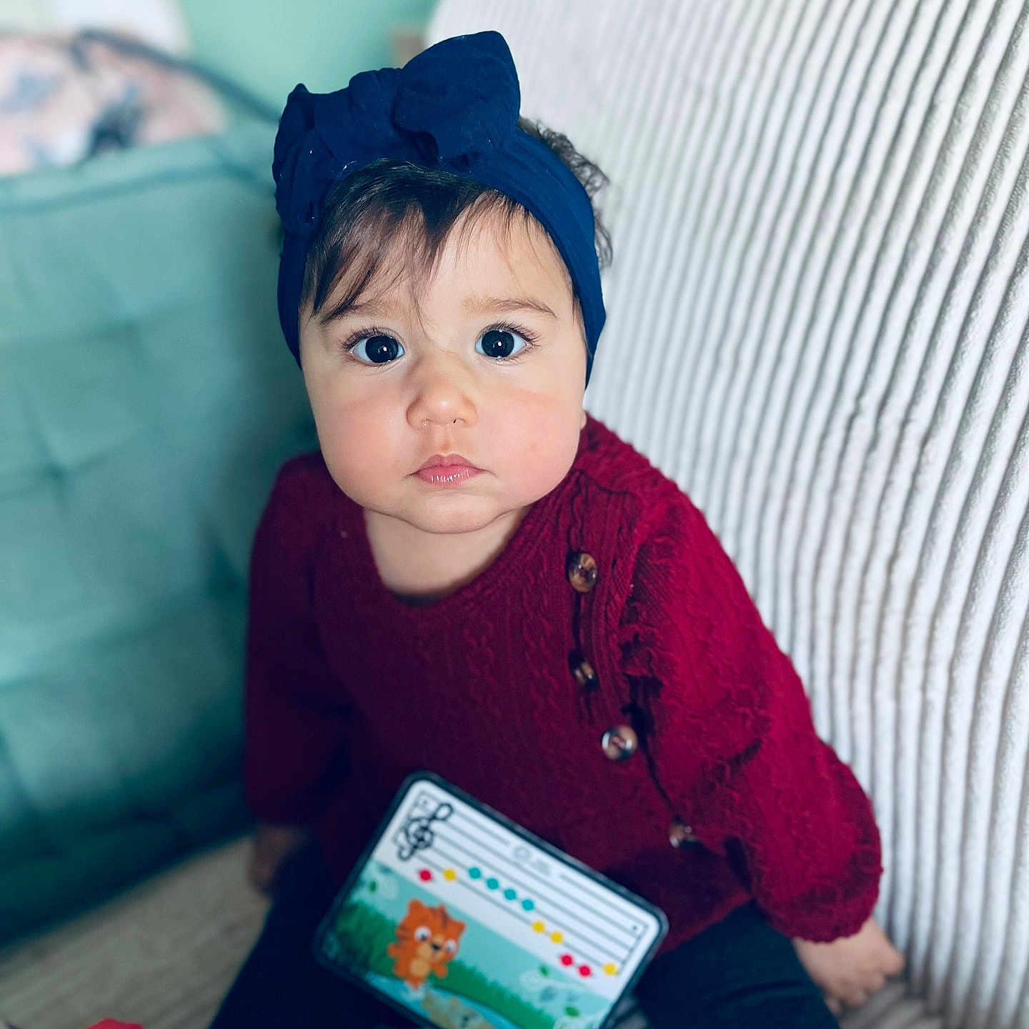 Charlotte a rejoint le concours — aidez-le/la à gagner de superbes lots ! baby, big_eyes, bow, buttons, cheeks, child, couch, curious_expression, face, hair, headband, indoor, knit_sweater, musical_toy, portrait, red_sweater, sitting, striped_couch, toddler, toy_piano