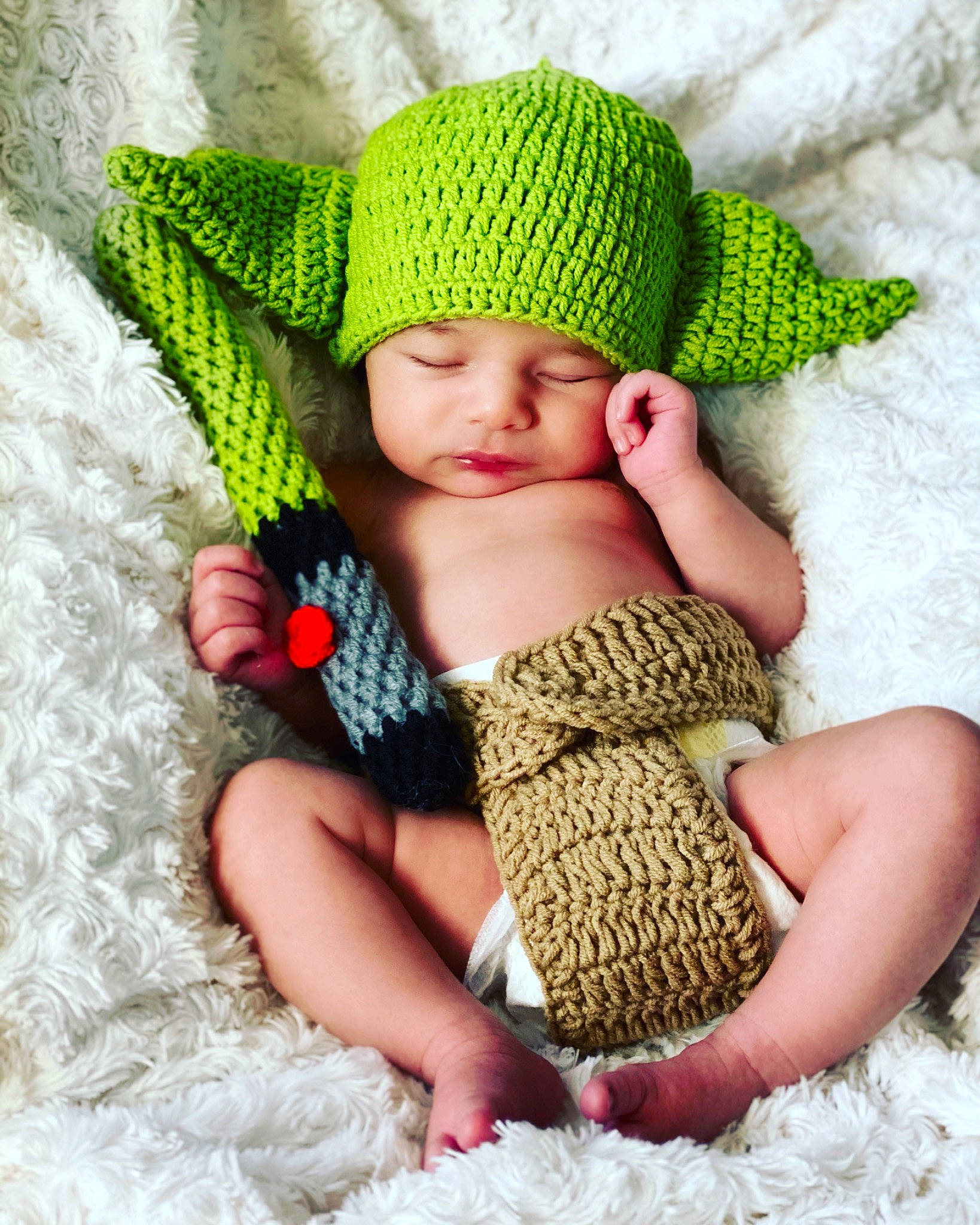 Nero is registered to the contest to win money with this photo: baby, baby_sleeping, baby_toddler_clothing, cap, child, comfort, grass, green, headgear, headwear, knit_cap, pattern, person, photograph, pink, product, skin, textile, toddler, wool